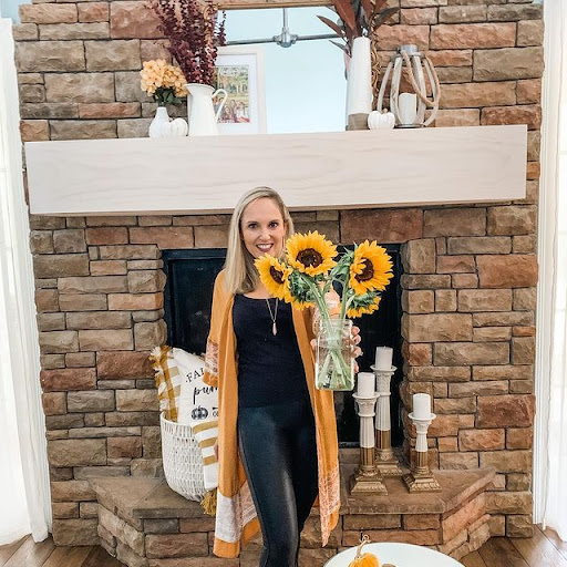 holding sunflowers in front of DIY fireplace mantle