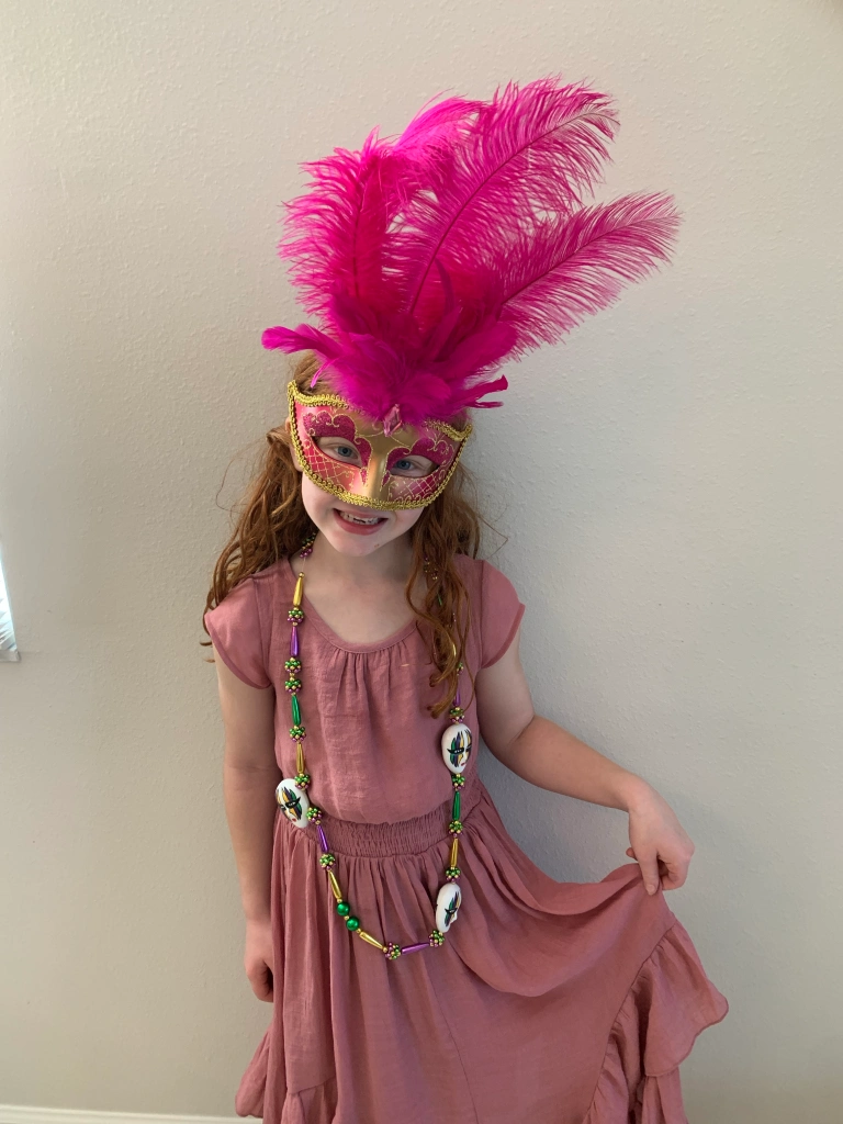 wearing Mardi Gras mask and necklace
